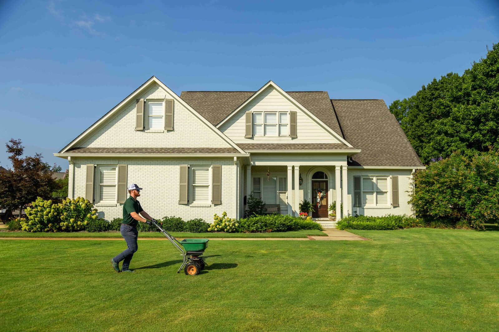lawn care technician granular treatment fertilizer spreader home front yard 3
