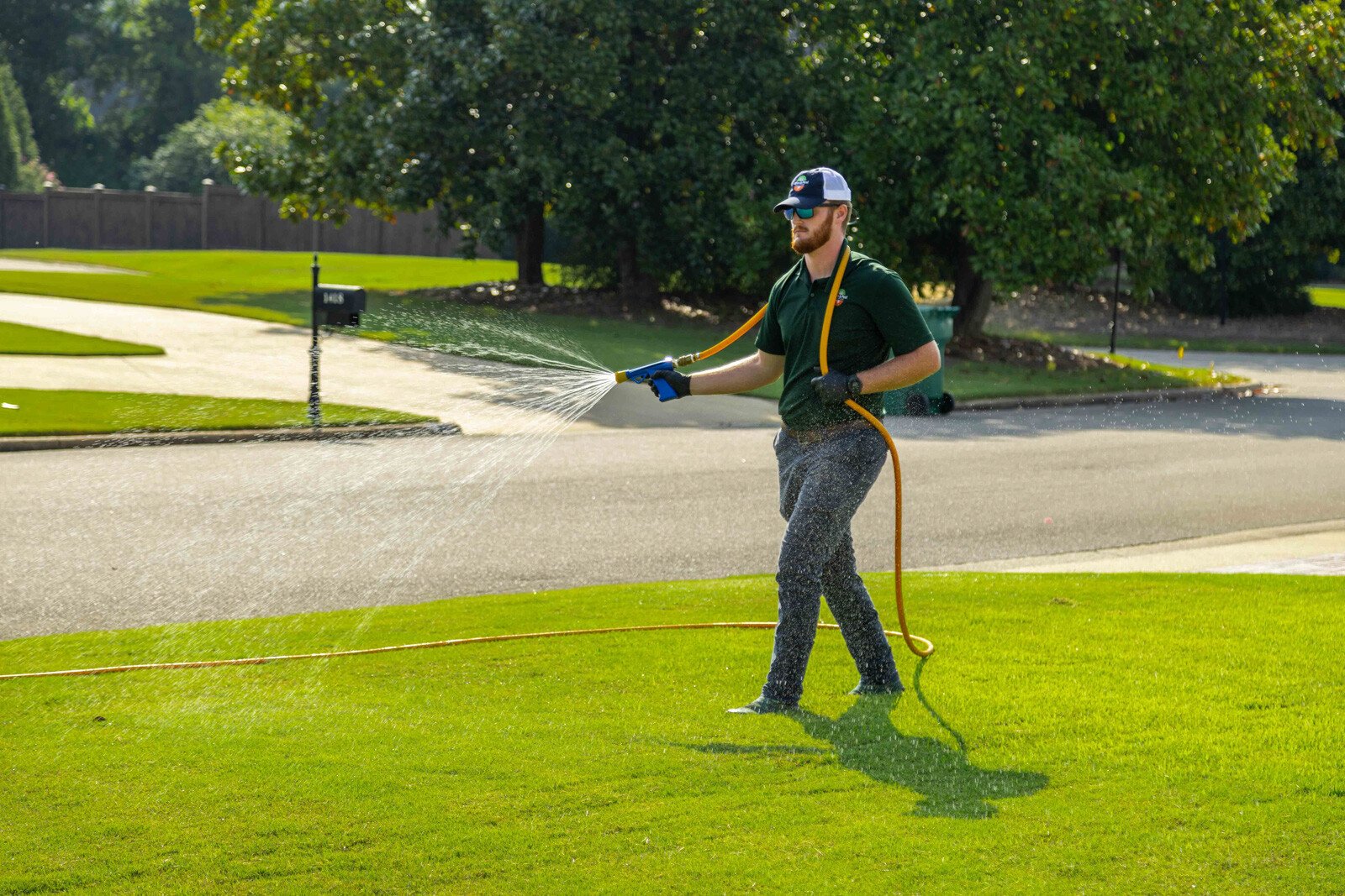 technician crew spray hose weed control lawn care grass green treatment