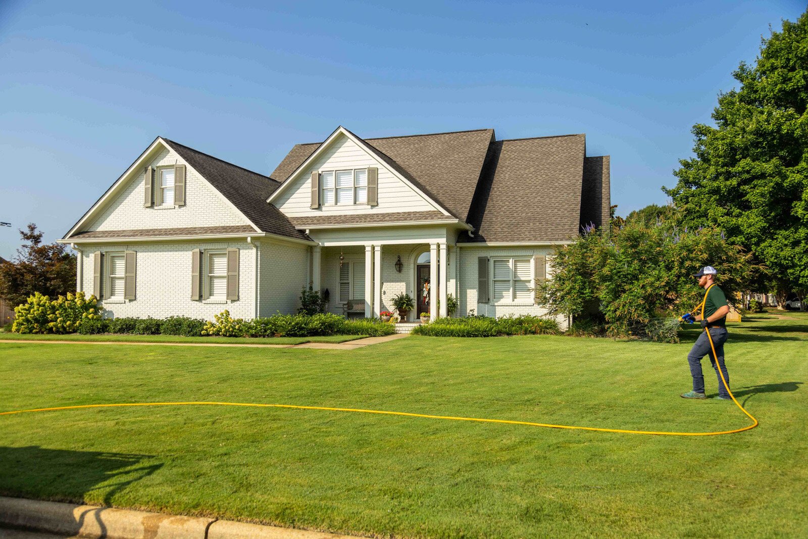 technician crew spray hose weed control lawn care grass green treatment home-1