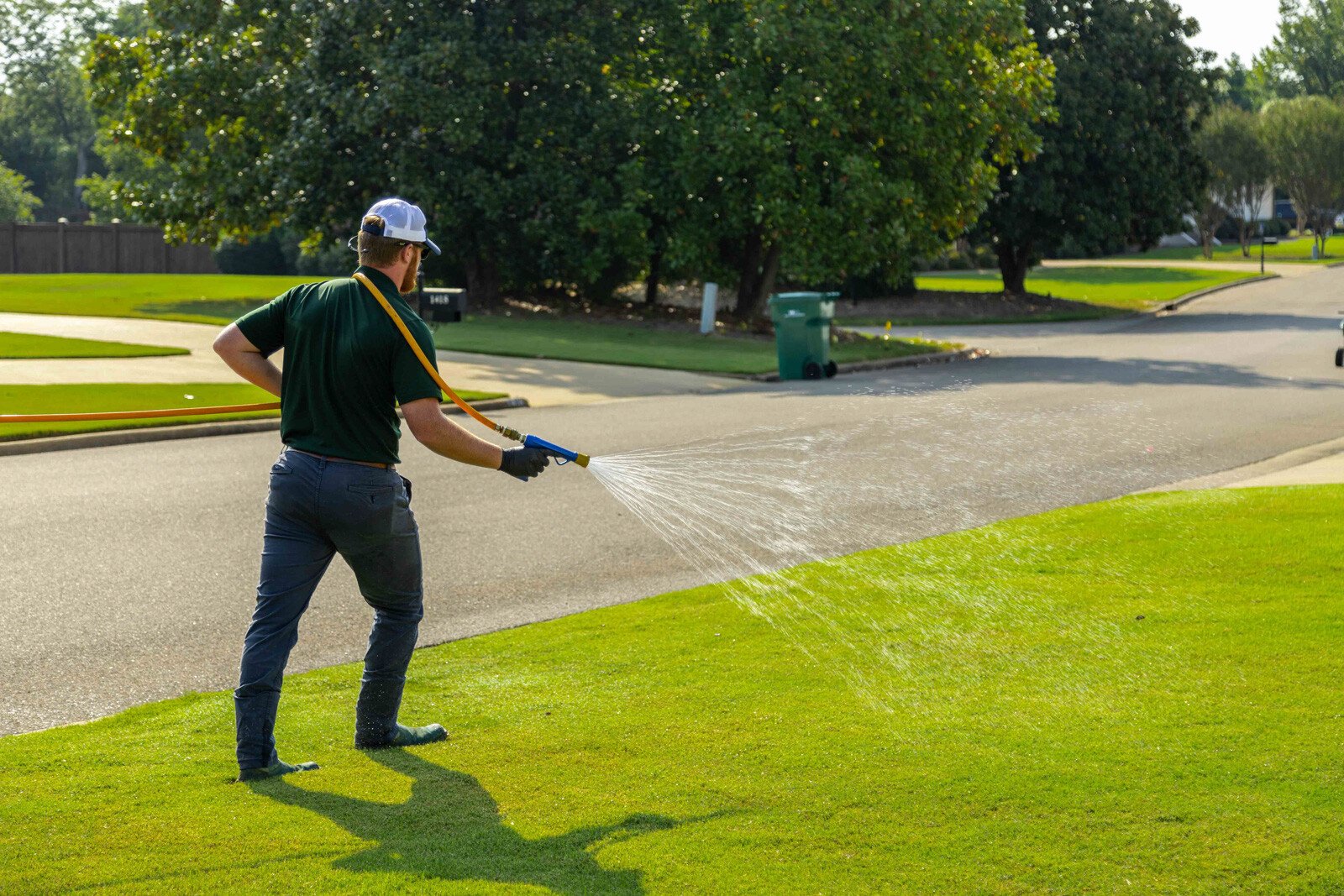 technician crew spray hose weed control lawn care grass green treatment