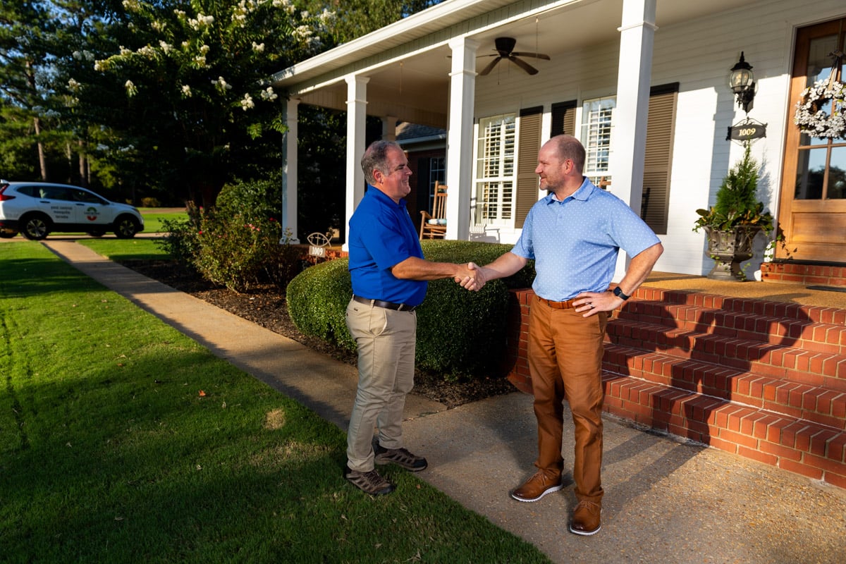 lawn care account manager and customer shaking hands before a lawn care consultation