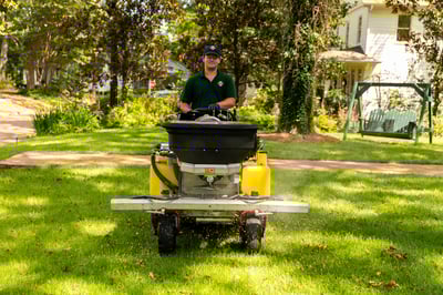 lawn care technician on liquid sprayer machine applying treatment to lawn 4