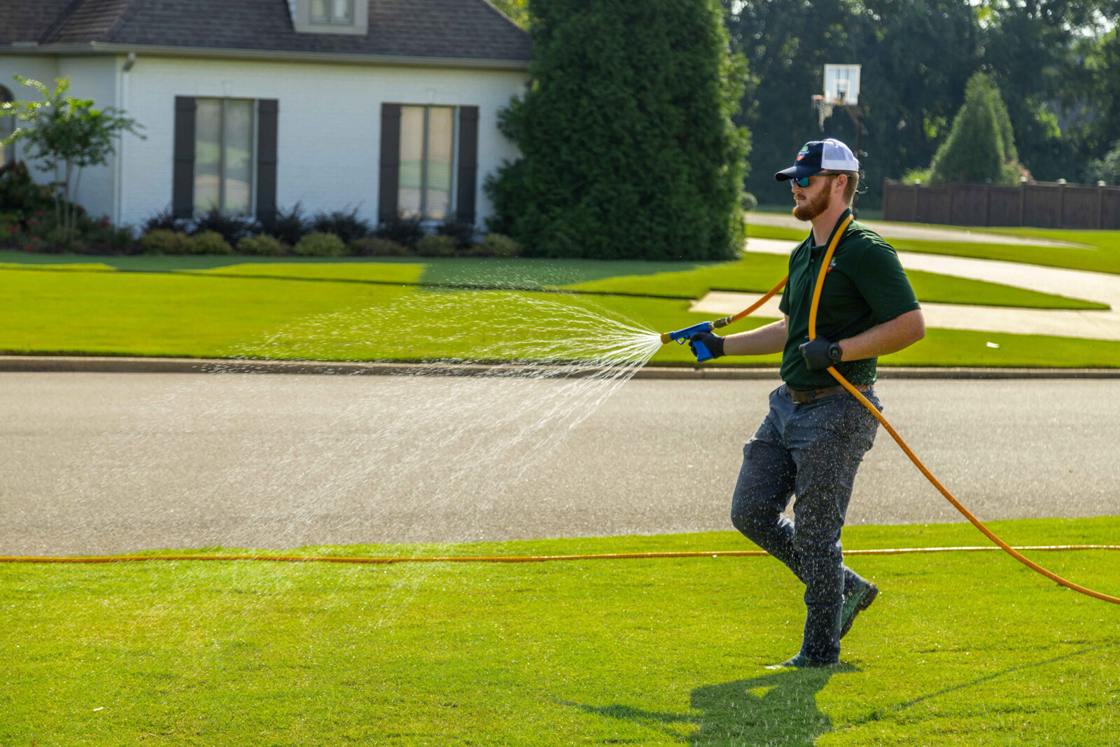 technician crew spray hose weed control lawn care grass green treatment 4