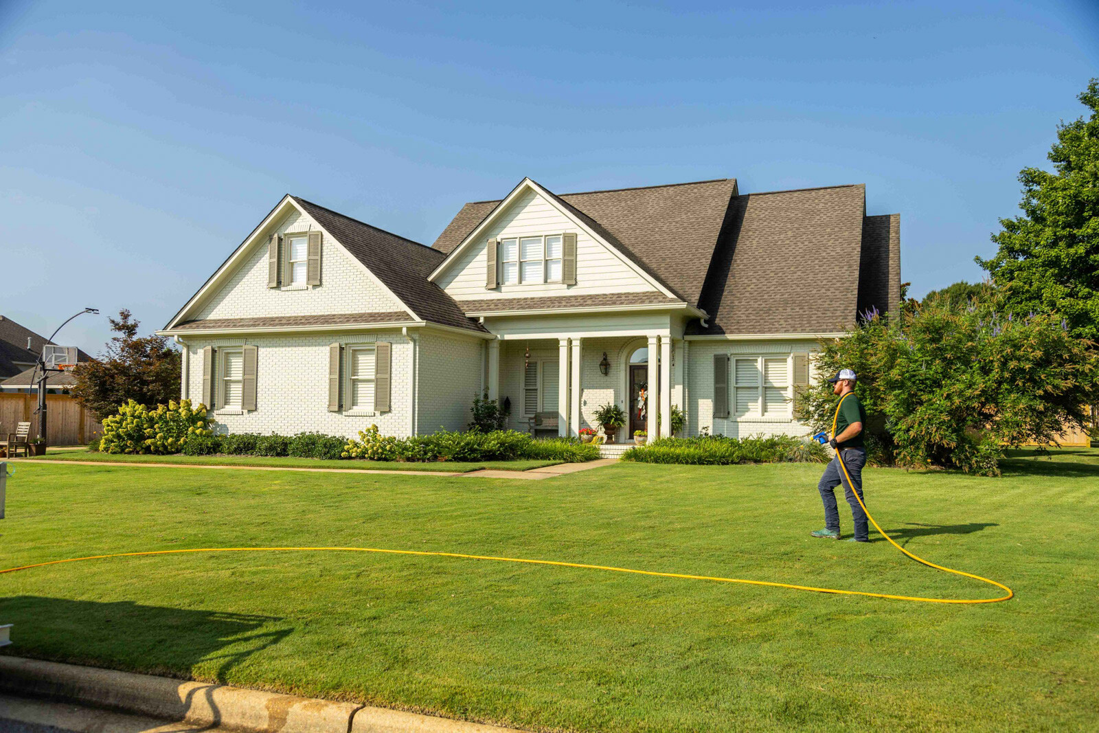 technician crew spray hose weed control lawn care grass green treatment home 2-1